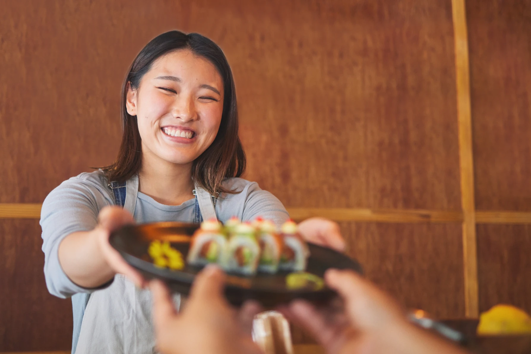 笑顔で料理を持つ女性